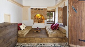 A cozy room with a stone fireplace, wooden furniture, and a rustic wooden door.