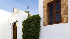 A white building with a stone window frame and a wooden door.