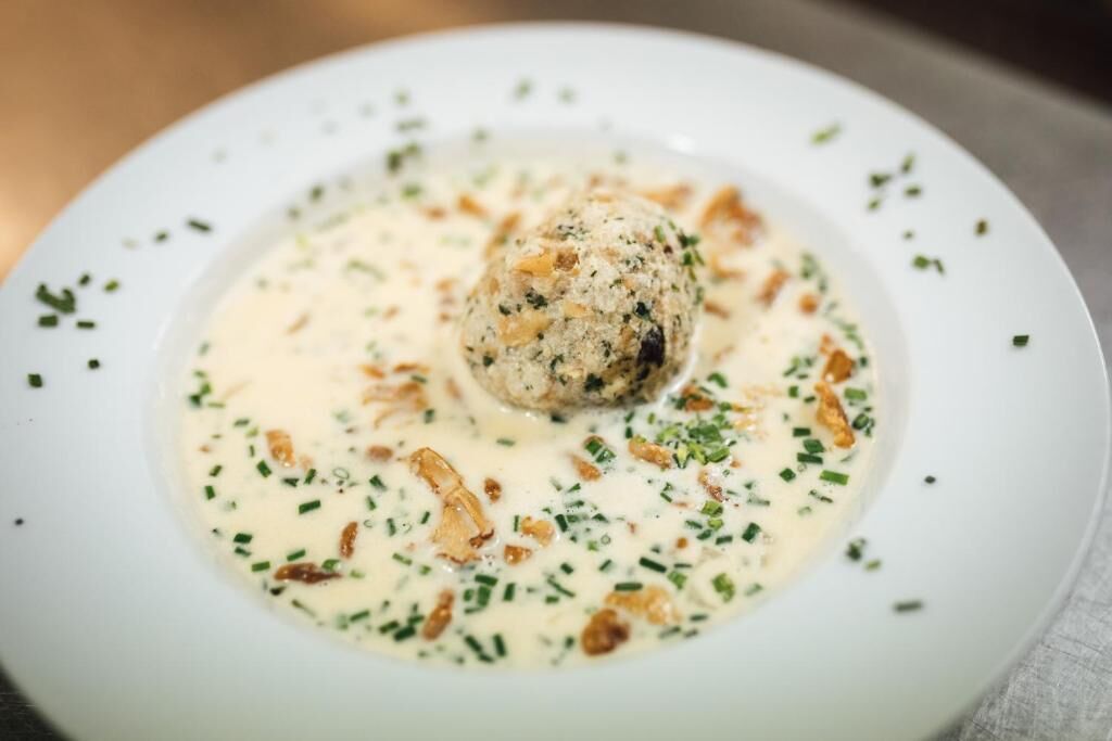 A plate of food with a creamy sauce, garnished with herbs and nuts.