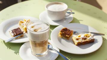 Una mesa con una taza de café y dos platos de postre.