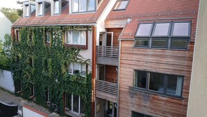 En bygning med flere etager, med restaurant i stueetagen, store vinduer og en balkon.