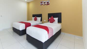 A hotel room with two beds, white bedding, red accents, and a yellow accent wall.