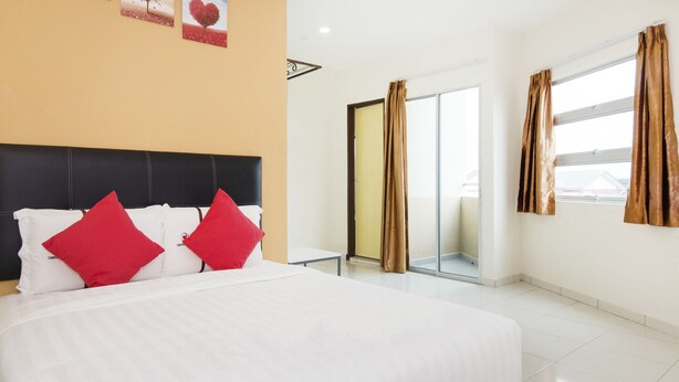 A hotel room with a large bed, a nightstand, a sliding glass door, and a view of the outside.