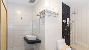 A modern bathroom with a white sink, a toilet, and a shower area.