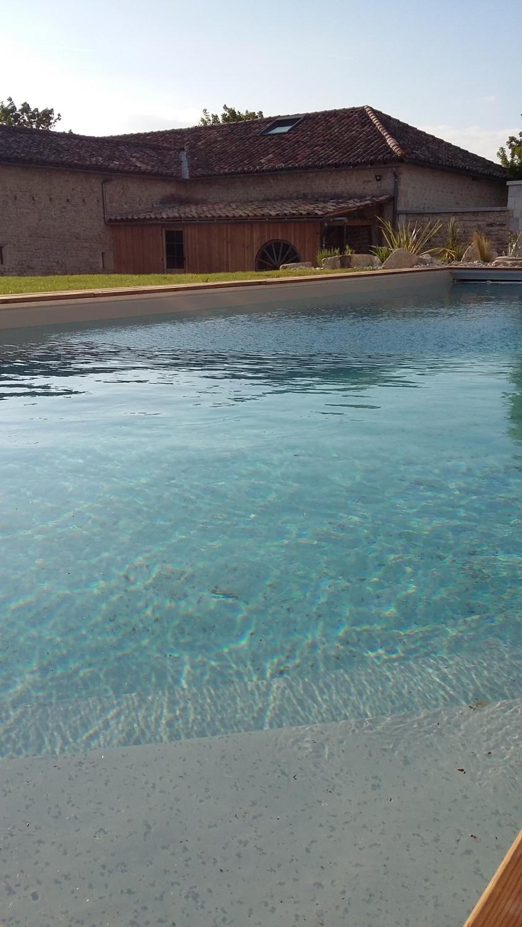 Ein klares Schwimmbecken mit einem Gebäude im Hintergrund.