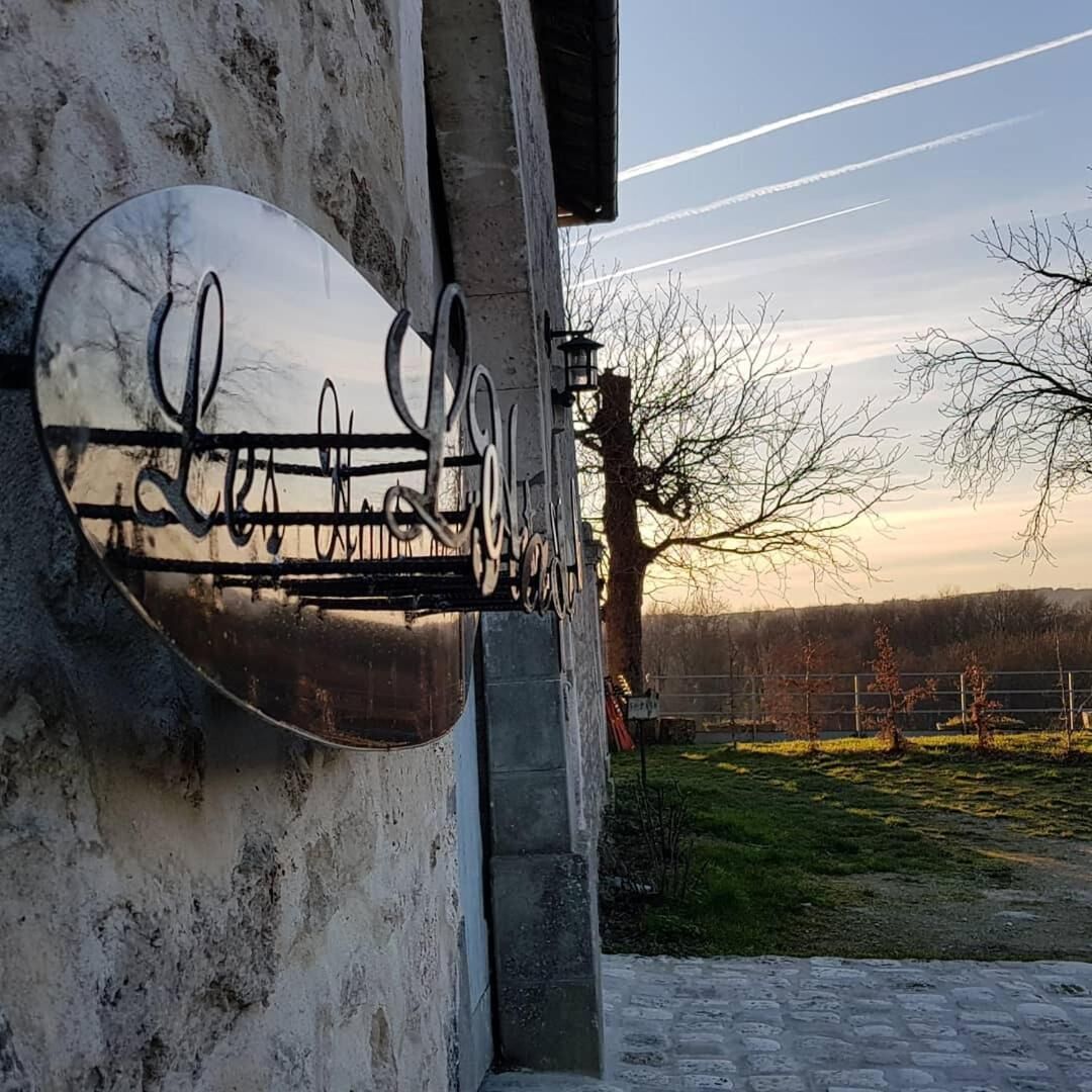 Una señal metálica con escritura cursiva en la pared exterior de un edificio.