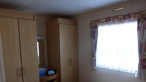 Un dormitorio con cama, escritorio, silla y armario.