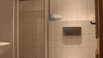 A bathroom with a toilet, a sink, and a shower enclosure.