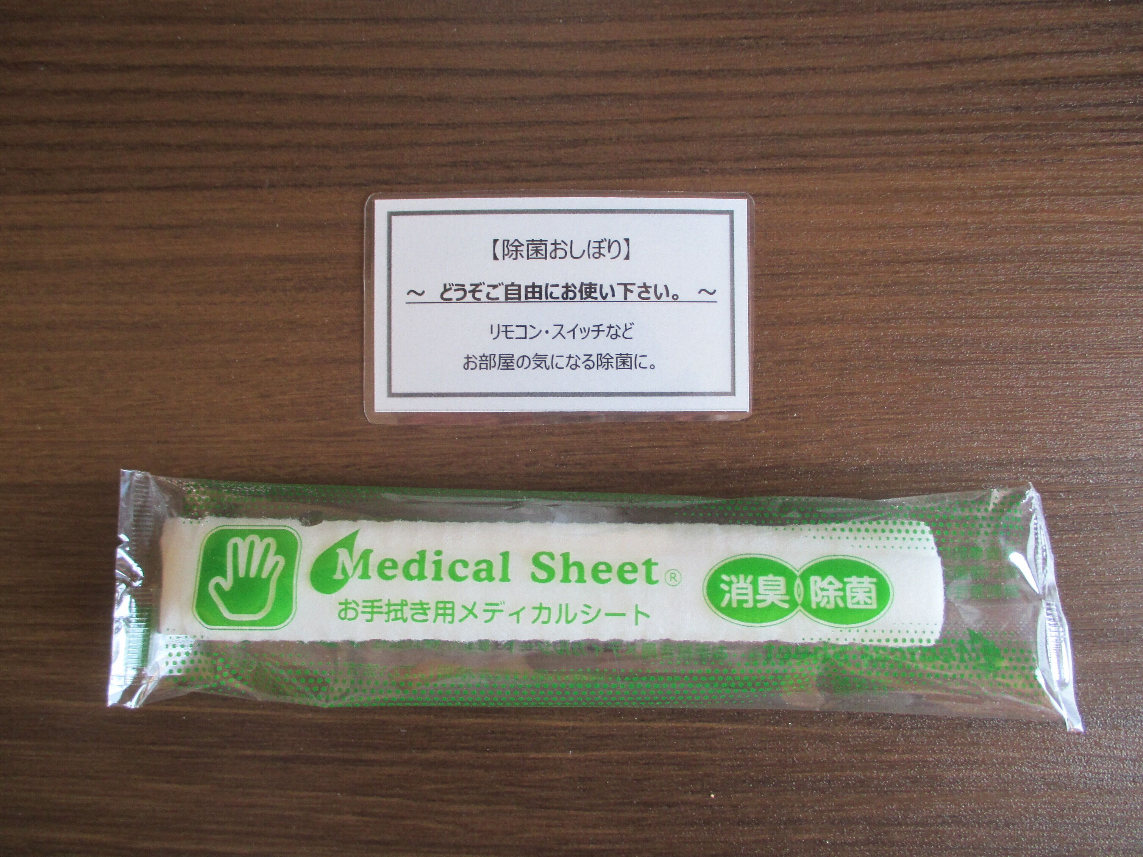 A medical sheet and a card with Japanese text on a wooden surface.