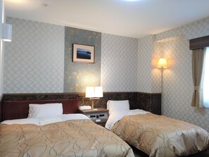 A hotel room with two beds, a nightstand, a lamp, a framed picture on the wall, and a window with curtains.