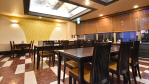 Un comedor con suelo a cuadros, una mesa grande y sillas.