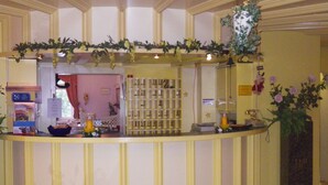 A reception area with a counter, a bulletin board, and a plant. - Hotel Stadt Baunatal (Baunatal)