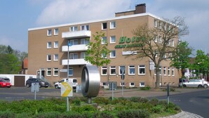 A hotel with a modern brick facade, multiple windows, and a sign indicating a restaurant. - Hotel Stadt Baunatal (Baunatal)
