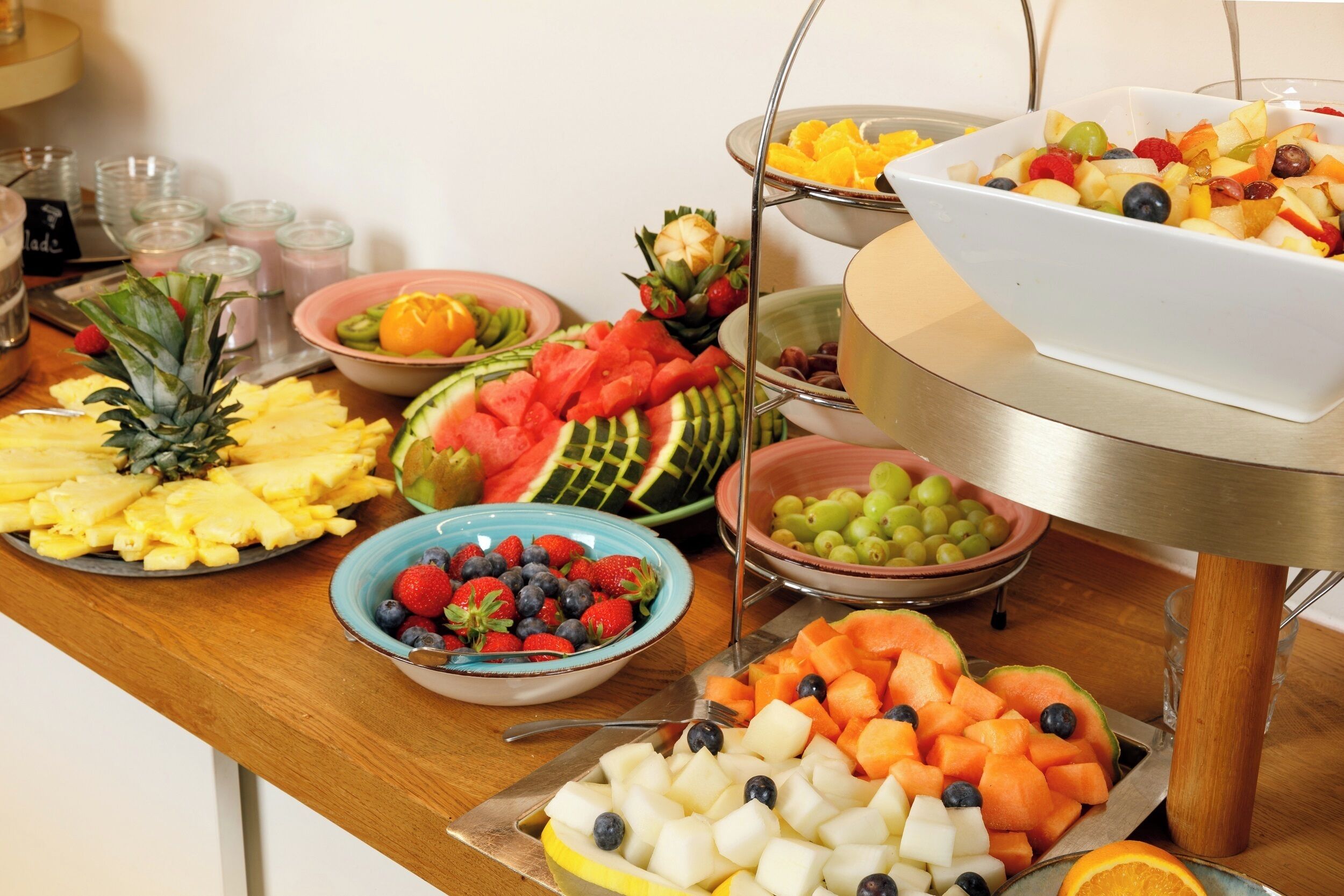 A buffet table with various fruits and vegetables.