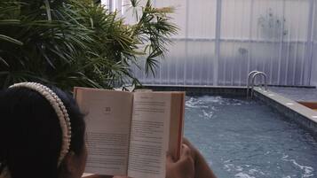 Una piscina al aire libre, sillones reclinables de piscina