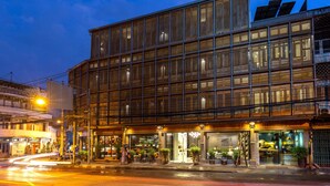 A modern building with large windows and a ground-level entrance. - The Bridge An Eclectic Luxotel Chiangmai (Chiang Mai)