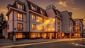 Um hotel com vários andares e uma placa chamativa com a inscrição 'HOTEL BOSS'.