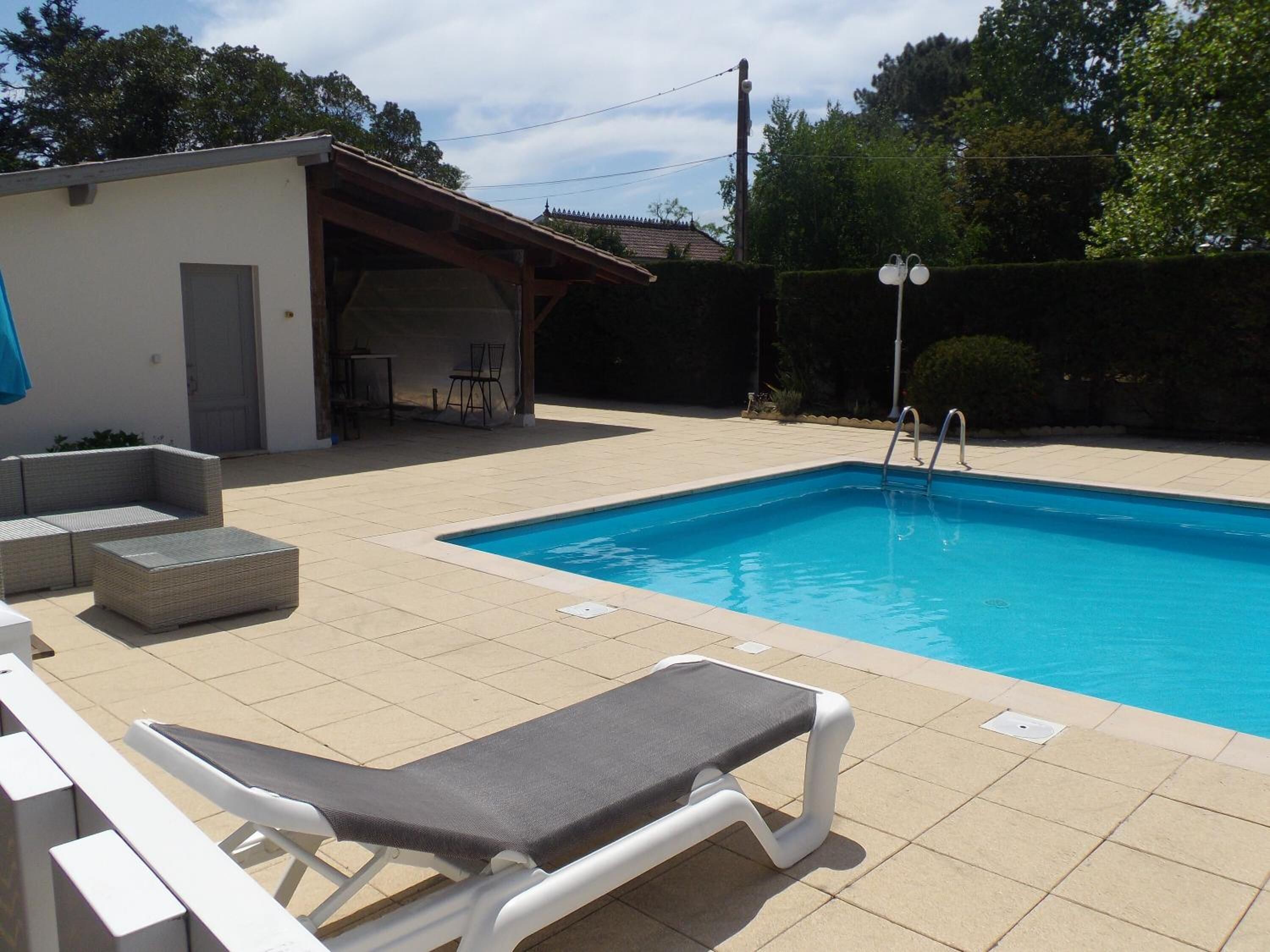 Una piscina al aire libre de temporada, sombrillas