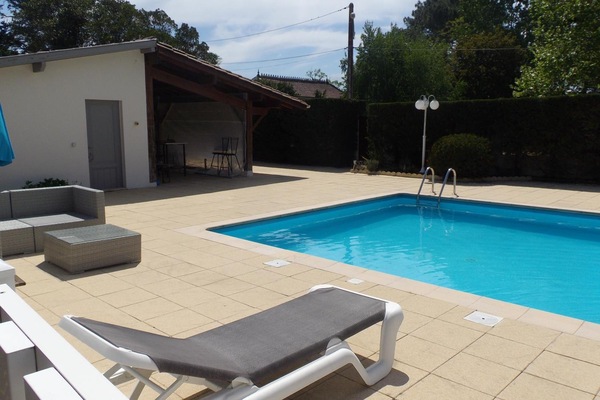 Una piscina al aire libre de temporada, sombrillas
