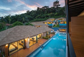 A modern resort with a large swimming pool, multiple guest rooms with large windows, and a lush tropical backdrop. - Chermantra Aonang Resort and Pool Suite (Krabi)