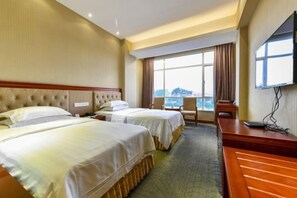 A hotel room with two beds, a desk, a chair, and a TV. - Wanghailou Hotel (Huizhou)