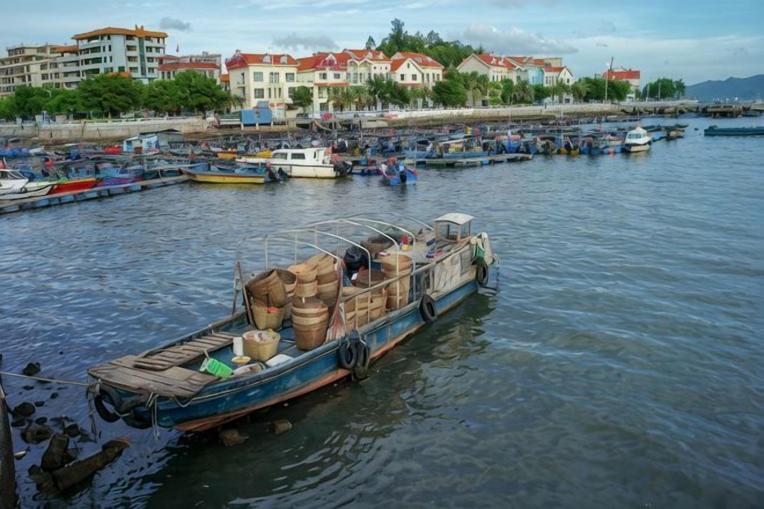 A harbor with boats docked, a waterfront building, and a clear sky.