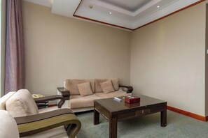 A living room with a sofa, a coffee table, and a chair. - Wanghailou Hotel (Huizhou)