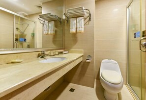 A bathroom with a sink, mirror, towel rack, toilet, and glass shower enclosure. - Wanghailou Hotel (Huizhou)