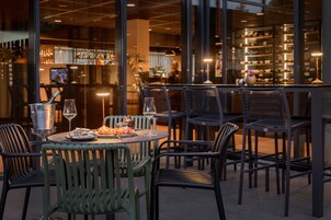 Un restaurante con terraza, zona de bar y vistas a la ciudad.