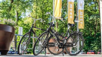 A bicycle parked near a metal fence with yellow banners in the background.