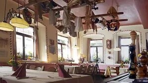 Uma sala de jantar com uma mesa comprida, cadeiras e luminárias pendentes.