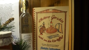Um livro de receitas intitulado 'Leckere Gerichte rund um die Kaffee' com ilustrações de comidas e utensílios de cozinha.