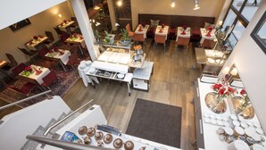A restaurant with multiple dining areas, a staircase, and a variety of table settings. - Maurers Zollamt Hotel (Kaiserslautern)
