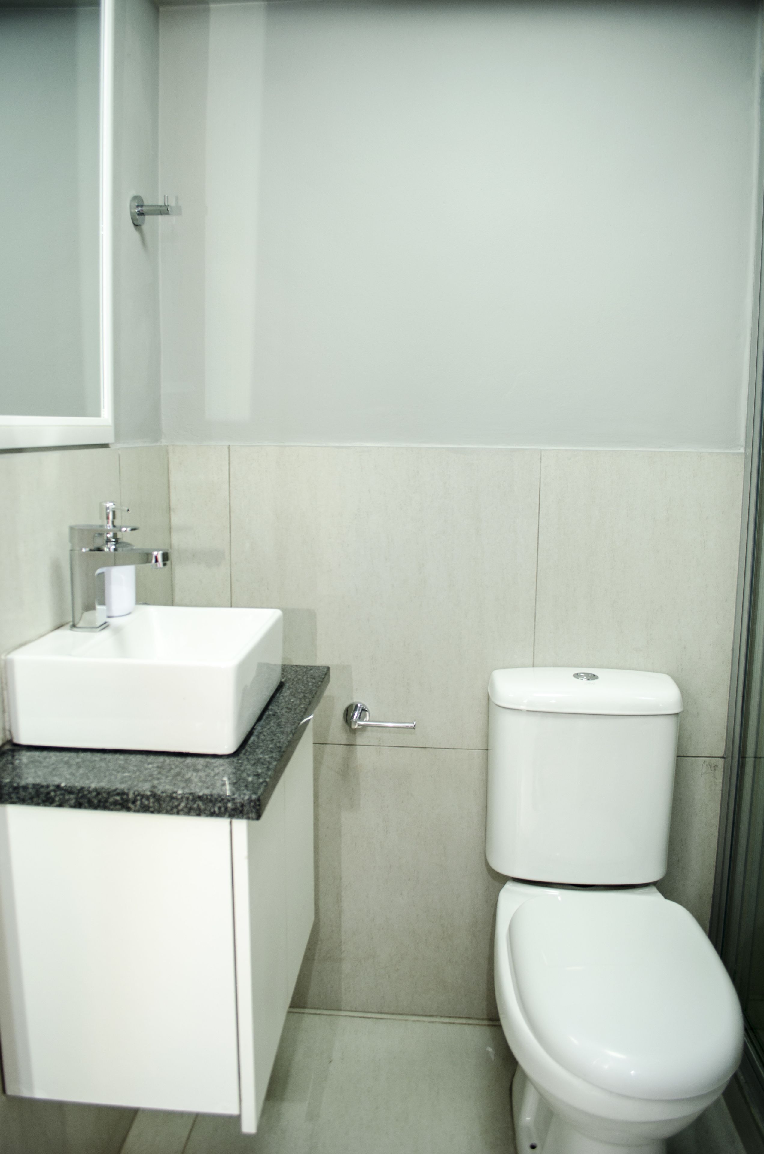 Een badkamer met een witte wastafel, toilet en kast.