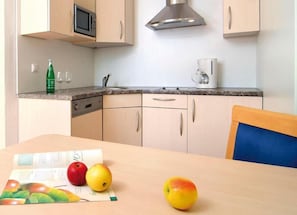 A kitchen with a microwave, coffee maker, and cabinets.