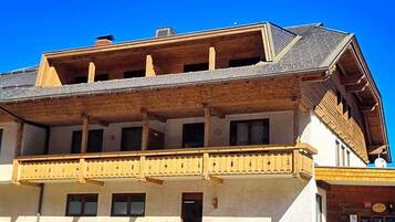 A multi-story building with a balcony and a wooden facade.