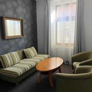 A living room with a sofa, a table, and two armchairs.