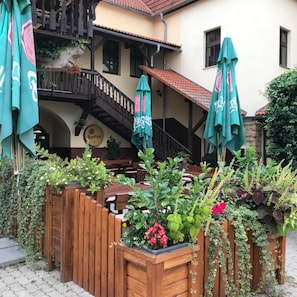 Een houten hek met planten in potten en tuinmeubilair.