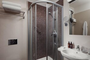 A modern bathroom with a glass-enclosed shower, a sink with a mirror, and toiletries. - Harvey SPA & KUR (Frantiskovy Lazne)