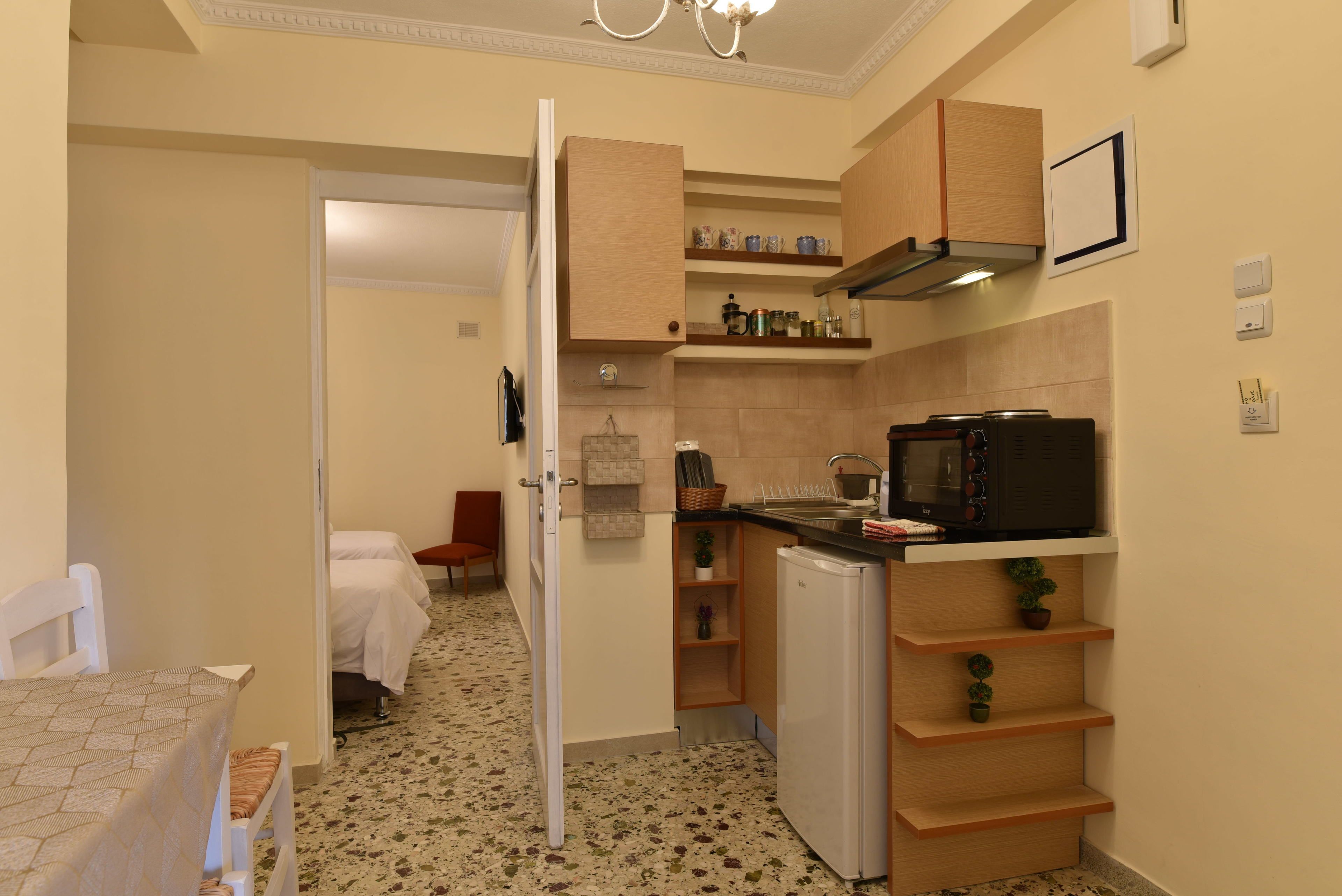 Una cocina compacta con microondas, refrigerador y estantes de madera.