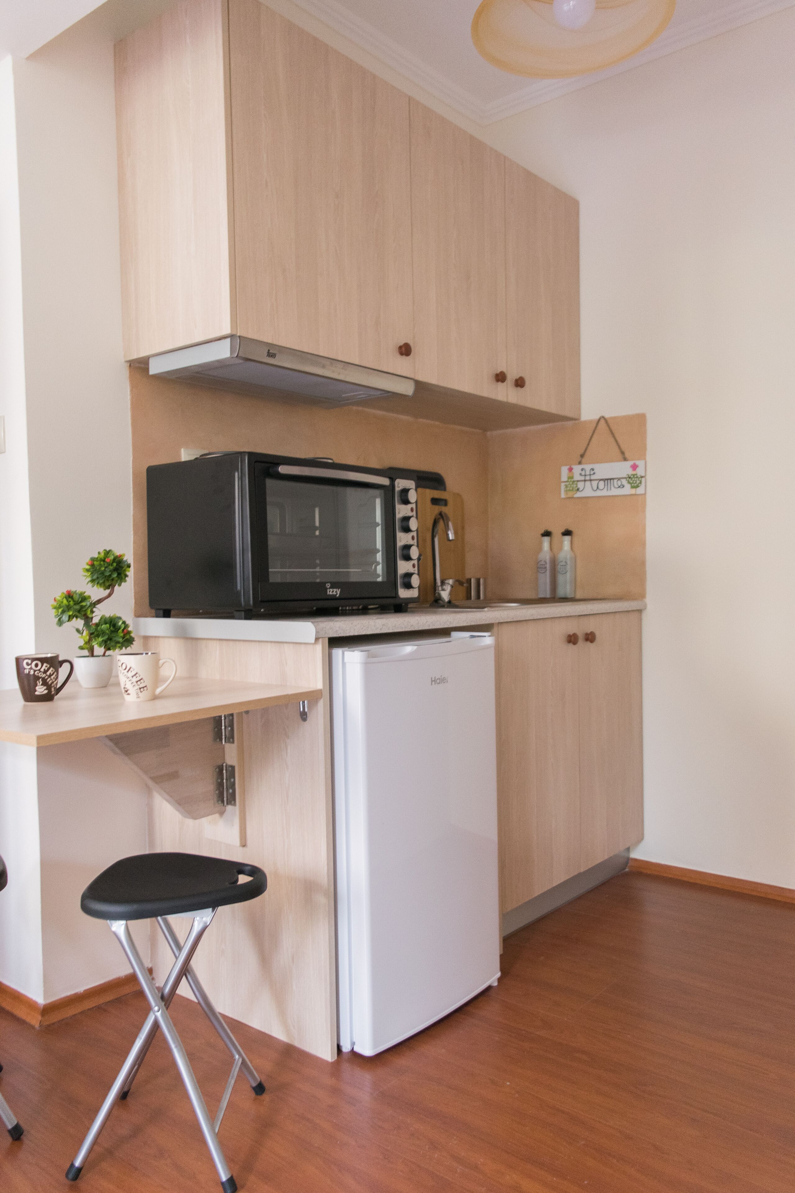 A compact kitchen with a microwave, toaster, and refrigerator.