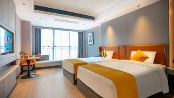 A hotel room with two beds, a seating area, a TV, and a balcony view.