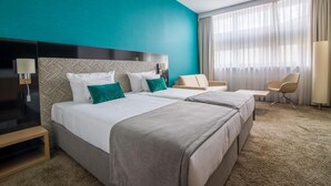 A hotel room with two beds, a desk, a chair, and a large window with curtains. - Hotel Ba Antowo Sport (Katowice)