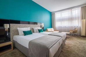 A hotel room with two beds, a desk, a chair, and a large window with curtains. - Hotel Ba Antowo Sport (Katowice)