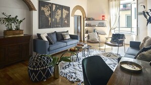 A cozy living room with a blue sofa, wooden coffee table, and a world map on the wall.