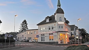 A hotel with a prominent tower and a sign indicating it is a hotel.