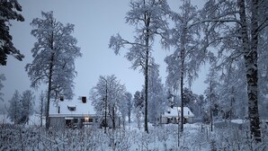 A snow-covered landscape with two houses surrounded by trees. - Vildmarks Lodge (Ytterhogdal)