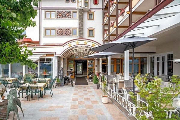 Un hôtel avec un sol à carreaux, des places assises en plein air et une entrée décorative.