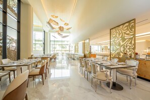 A spacious restaurant with high ceilings, large windows, and a modern interior design. - Savoy Palace - The Leading Hotels of the World - Savoy Signature (Funchal)