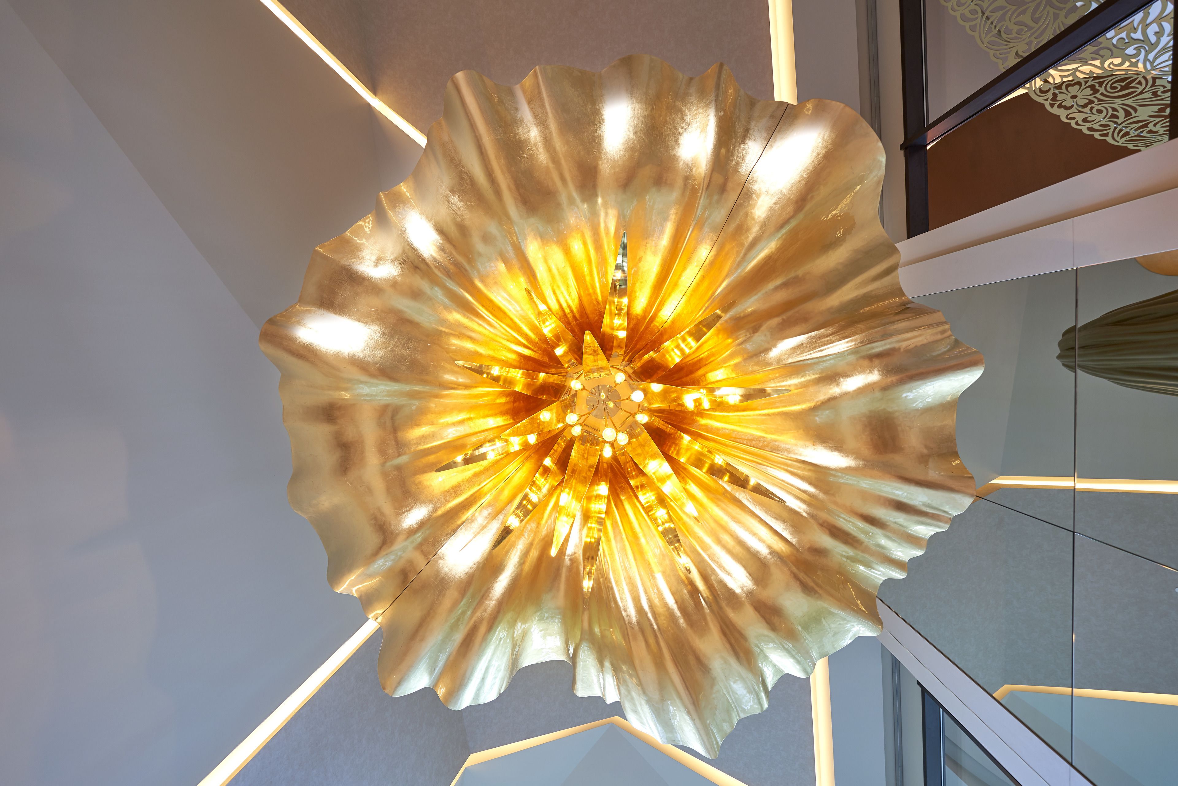 A large, metallic, flower-shaped light fixture with a central glowing bulb.